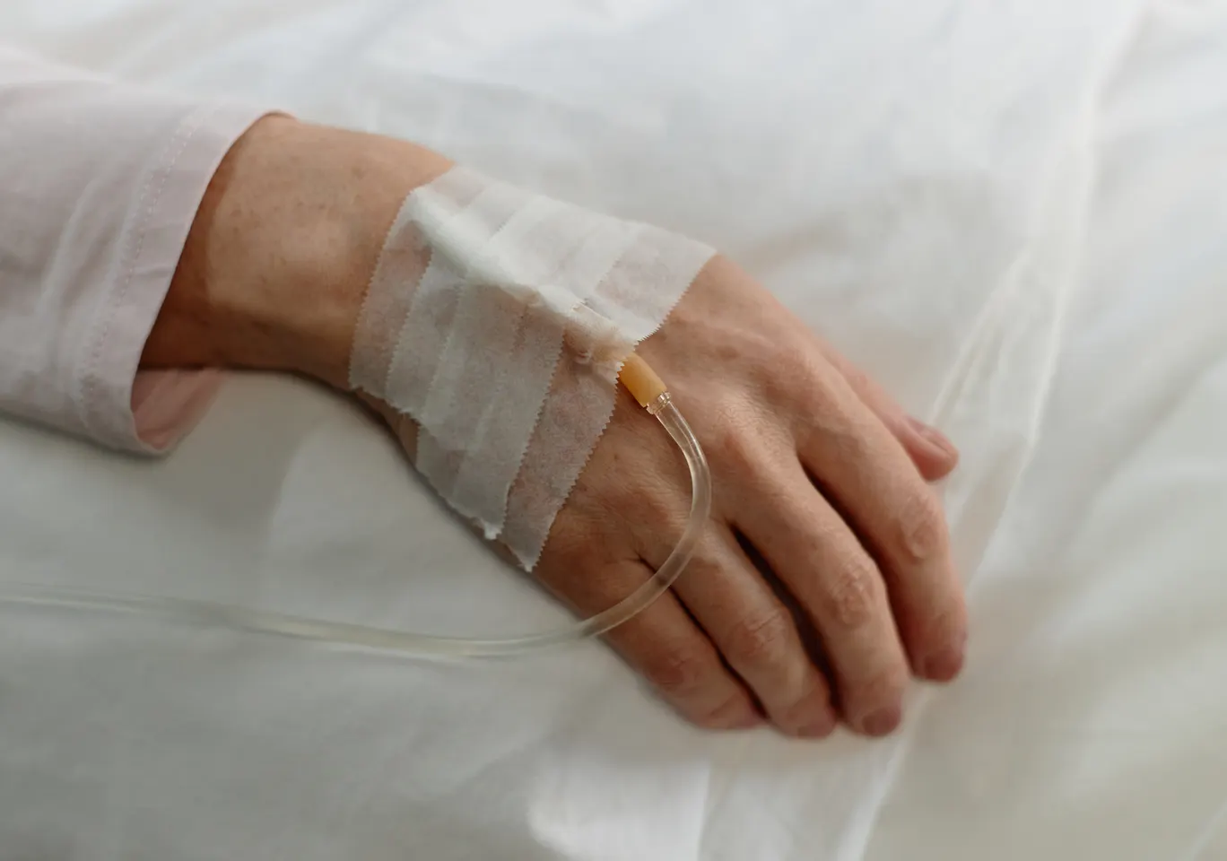 Kroplówki witaminowe Zakliczyn: dłoń z podłączoną kroplówką w spokojnym kadrze