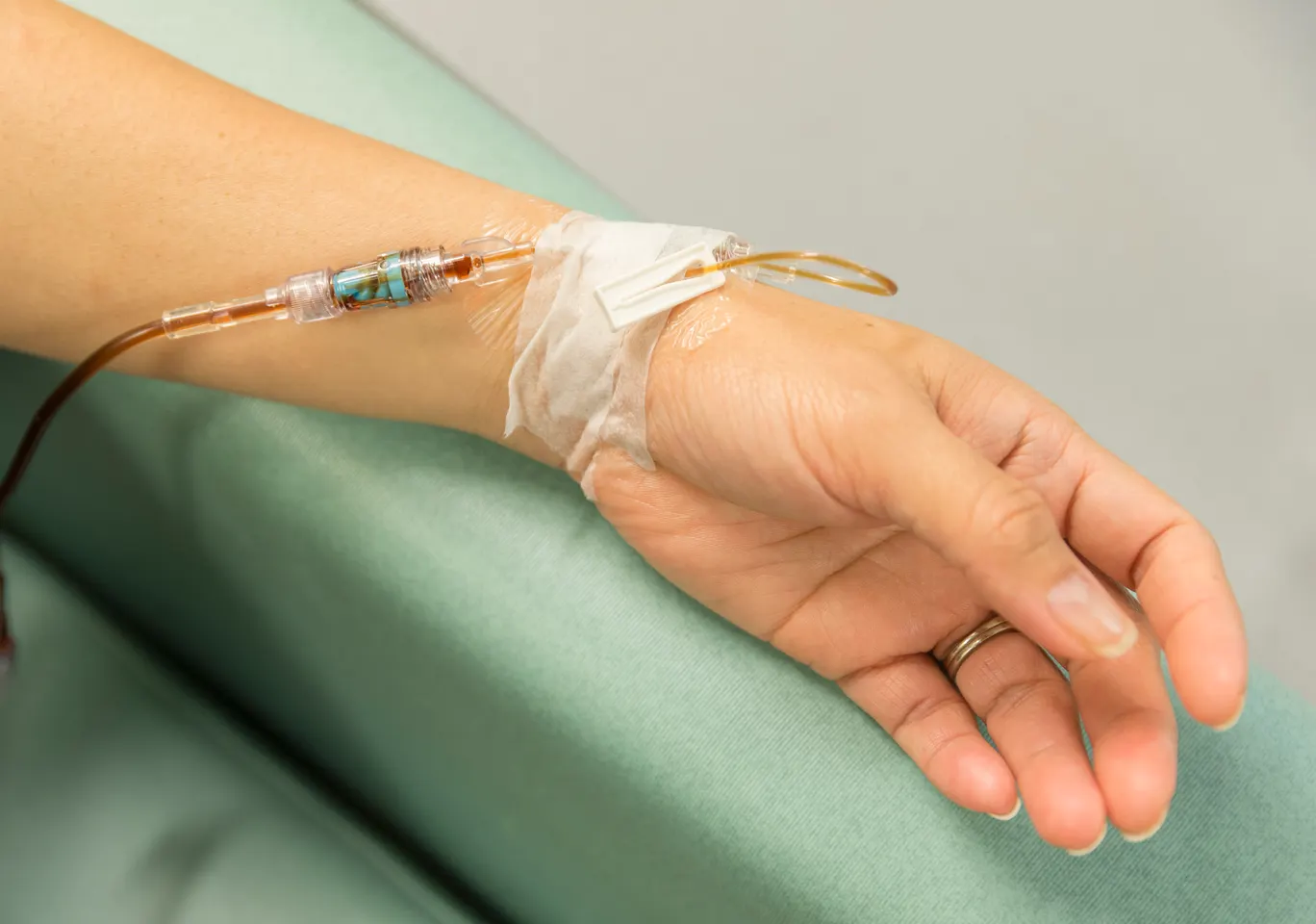 Kroplówki witaminowe Tarnów: dłoń z wenflonem i linią infuzyjną na podkładzie